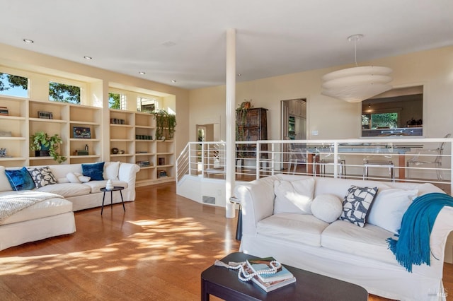 living area with recessed lighting, stairway, and wood finished floors