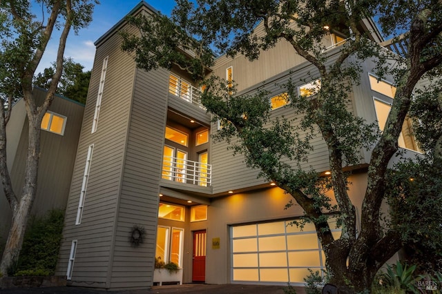 view of front of home featuring a garage and a balcony