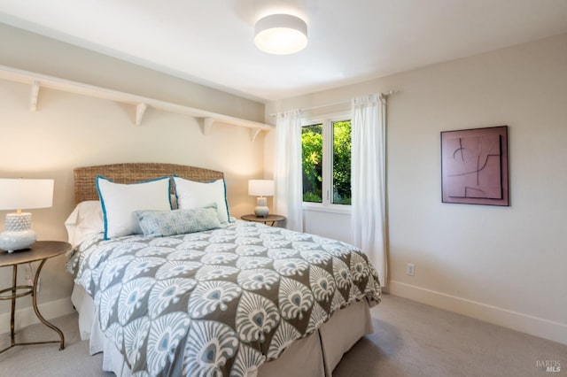 bedroom with baseboards and light colored carpet