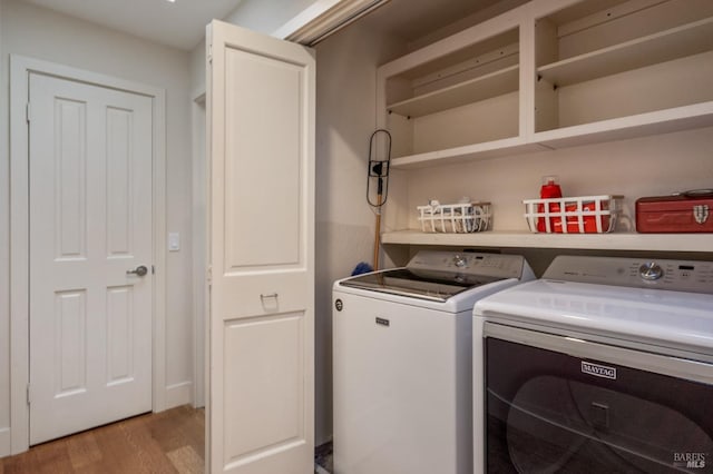 washroom with laundry area, washer and clothes dryer, and light wood-style floors