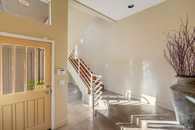 foyer with stairway, tile patterned flooring, and baseboards