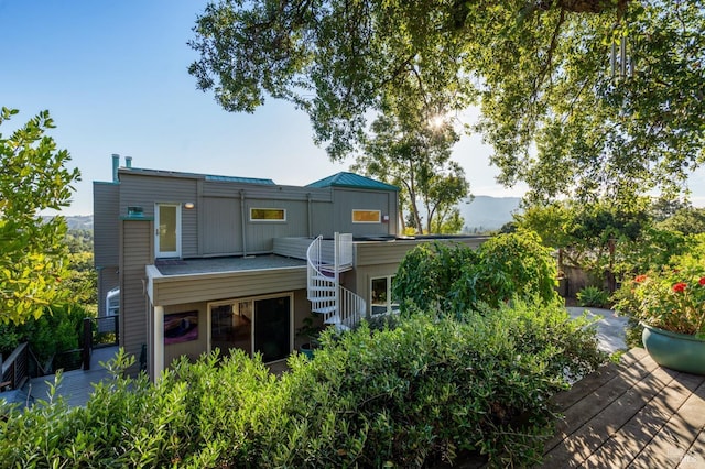 back of house with stairway, a standing seam roof, metal roof, and a deck with mountain view