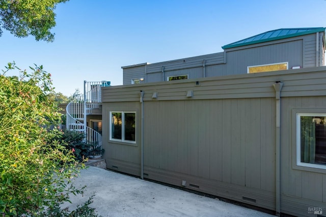 exterior space with crawl space, a standing seam roof, stairs, and metal roof