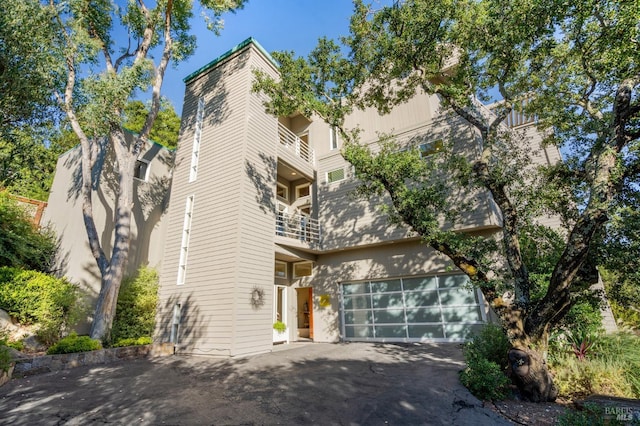 view of side of home featuring driveway and an attached garage