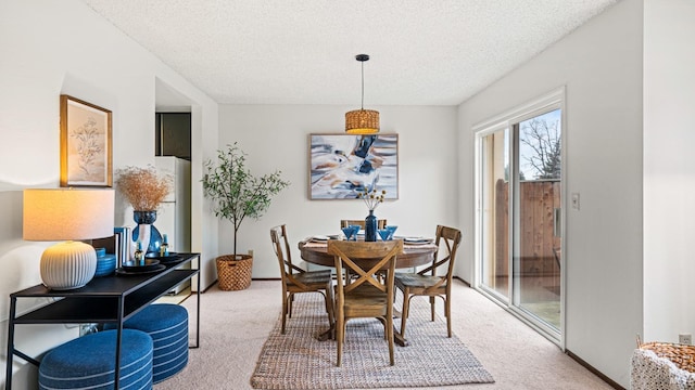 dining area with carpet and a textured ceiling