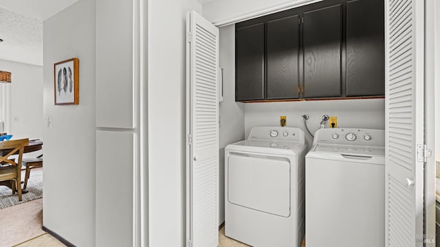 washroom with light carpet, cabinets, washer and clothes dryer, and a textured ceiling