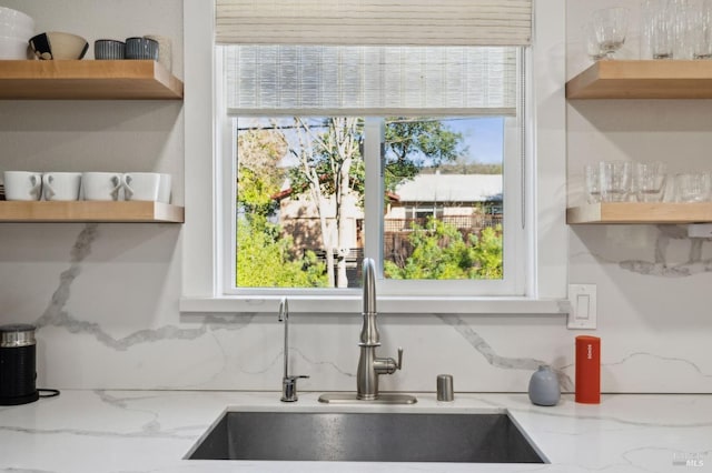 kitchen featuring sink, light stone countertops, and tasteful backsplash