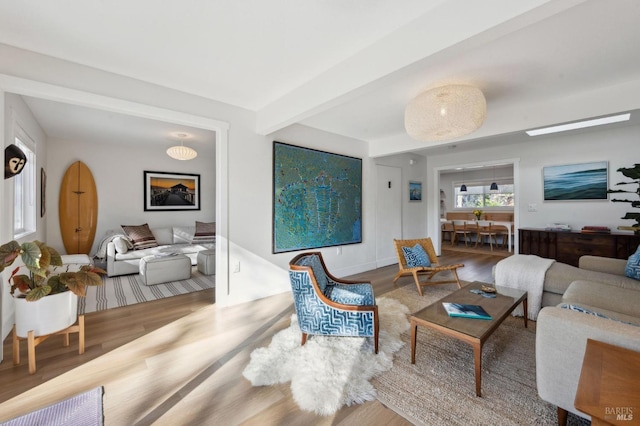 living room featuring beam ceiling and hardwood / wood-style floors