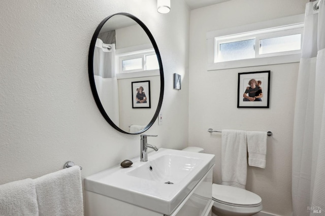 bathroom featuring sink, toilet, and a healthy amount of sunlight