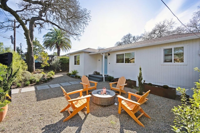 rear view of house with a patio and a fire pit