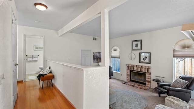 hallway featuring carpet, visible vents, and beamed ceiling