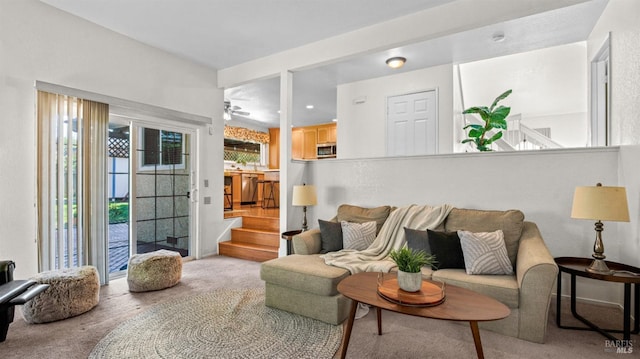 living area with carpet and ceiling fan