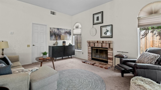 living room with carpet, a fireplace, and visible vents