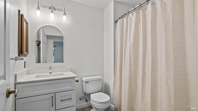 full bath with vanity, toilet, and baseboards