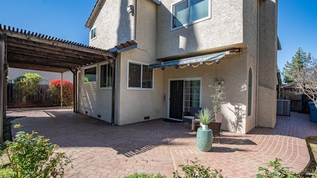 rear view of property with crawl space, a patio area, fence, and stucco siding