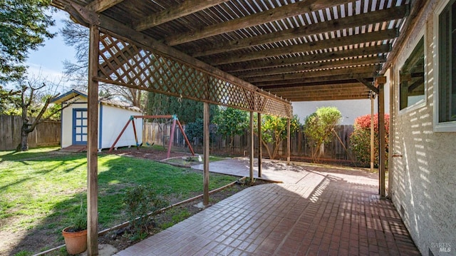 view of patio with an outbuilding, a playground, a shed, a pergola, and a fenced backyard