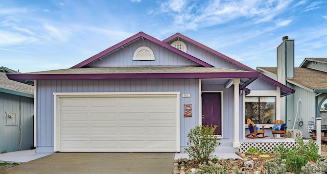 view of front of home with a garage, driveway, a shingled roof, and covered porch