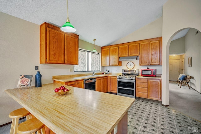 kitchen with a sink, a peninsula, double oven range, dishwasher, and under cabinet range hood