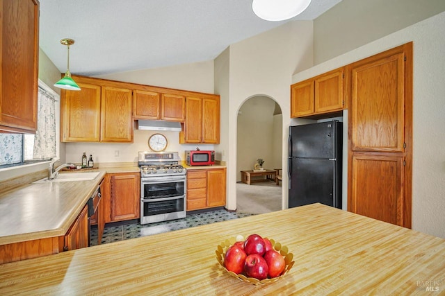 kitchen featuring arched walkways, hanging light fixtures, vaulted ceiling, under cabinet range hood, and black appliances