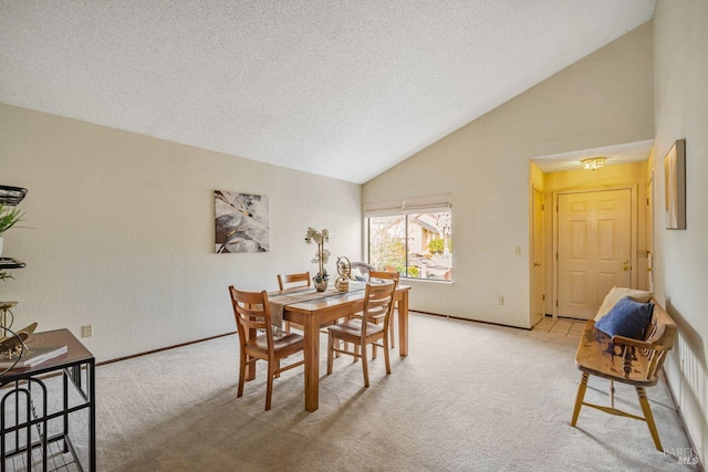 dining room featuring high vaulted ceiling, light carpet, a textured ceiling, and baseboards