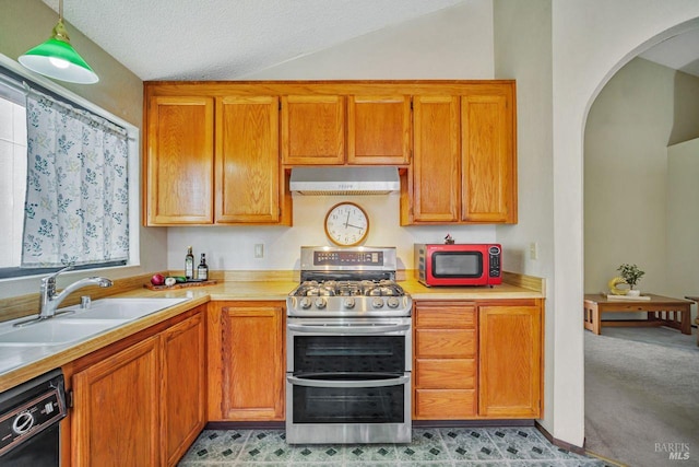 kitchen featuring black dishwasher, arched walkways, range with two ovens, under cabinet range hood, and a sink