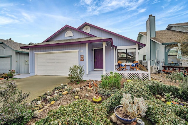 view of front of house featuring covered porch, concrete driveway, and an attached garage