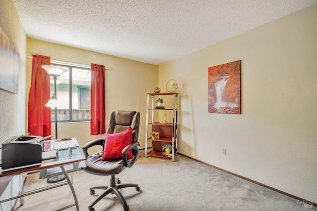 carpeted home office with a textured ceiling and baseboards