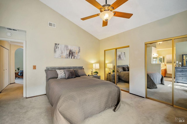 carpeted bedroom featuring arched walkways, multiple closets, visible vents, ceiling fan, and high vaulted ceiling