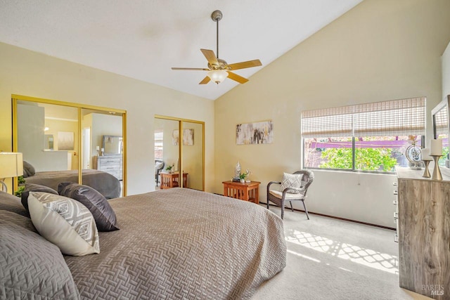 bedroom featuring vaulted ceiling, carpet, two closets, and a ceiling fan