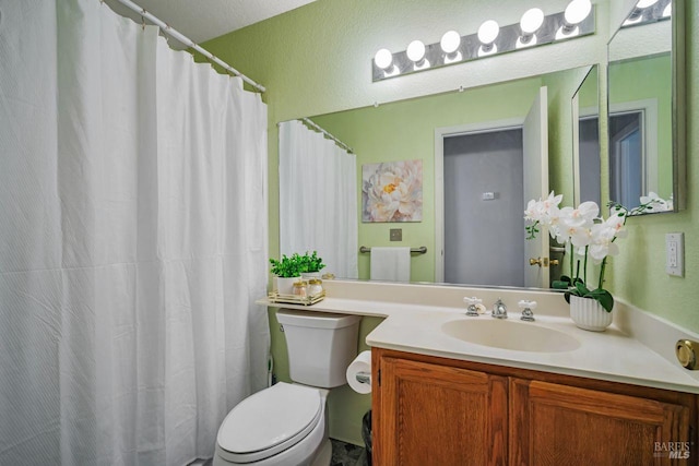 bathroom featuring toilet, a shower with shower curtain, and vanity