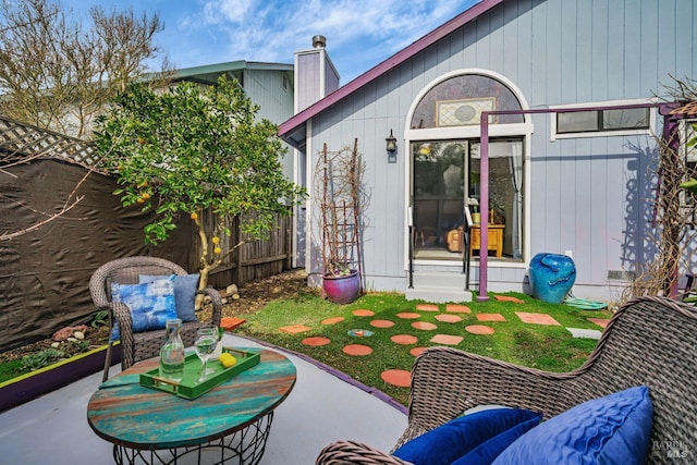 exterior space featuring a patio area, fence, and a chimney