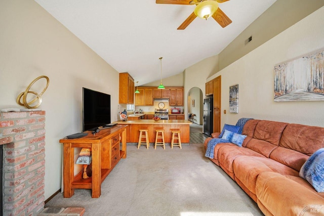 living area with arched walkways, lofted ceiling, visible vents, light colored carpet, and ceiling fan