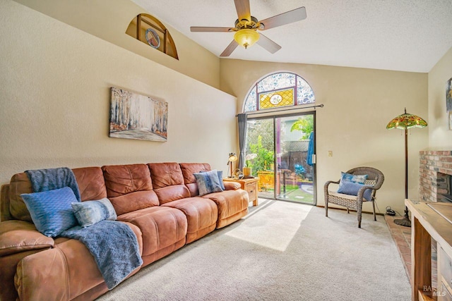 carpeted living area featuring lofted ceiling, ceiling fan, a textured ceiling, and a fireplace