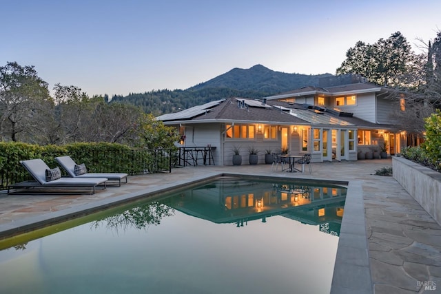 view of swimming pool featuring a fenced in pool, a mountain view, and a patio