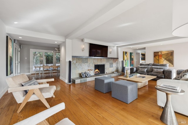 living area with light wood finished floors, a fireplace, baseboards, and recessed lighting