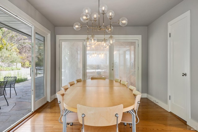 dining area with a notable chandelier, baseboards, and wood finished floors