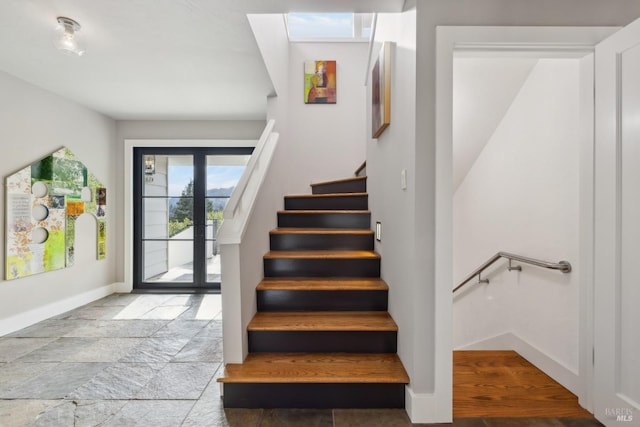 stairs with stone tile floors and baseboards