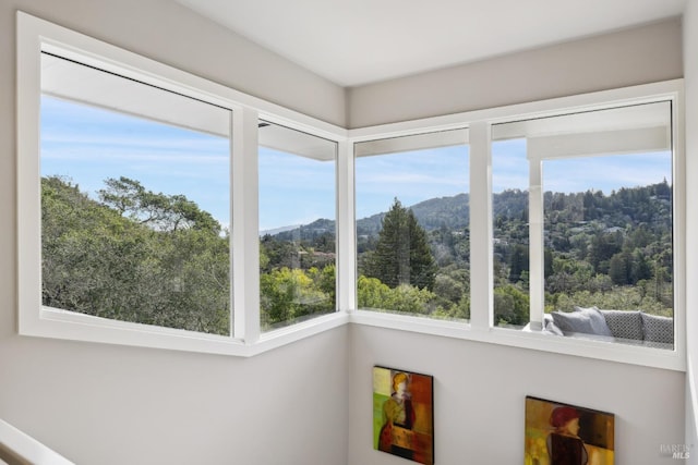 sunroom / solarium featuring a mountain view and a view of trees