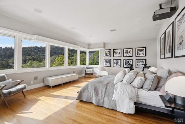 bedroom featuring visible vents, light wood-style flooring, and baseboards