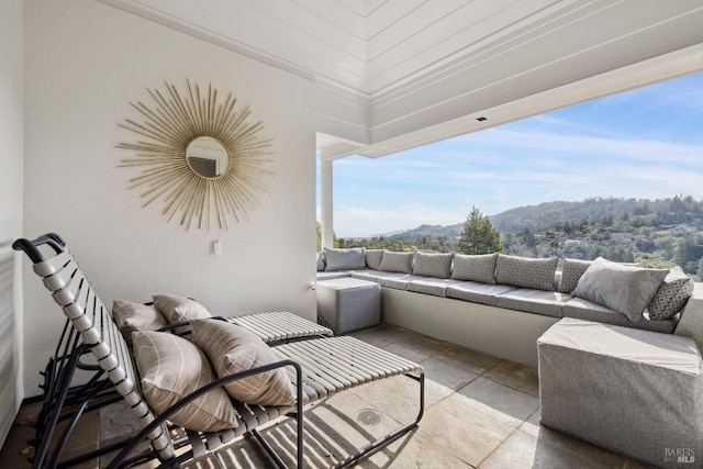 balcony with a mountain view, a patio, and an outdoor living space