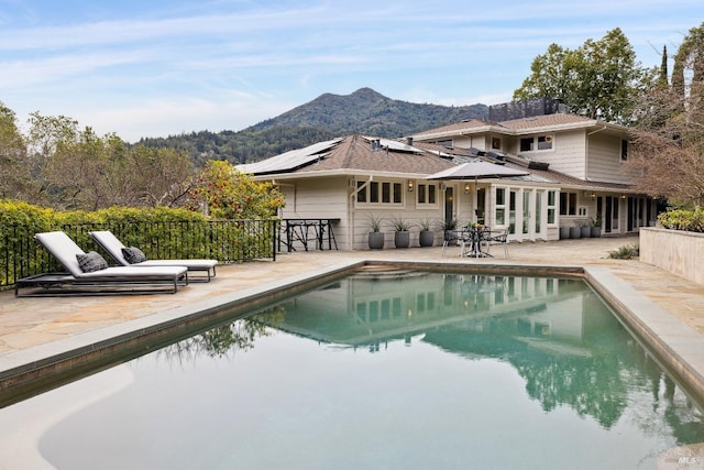 pool with a patio area and a mountain view