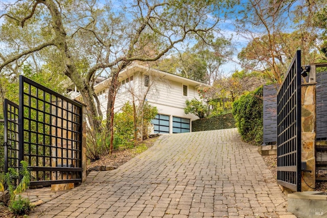 view of home's exterior featuring a garage and decorative driveway