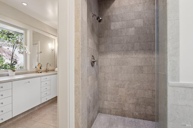 bathroom featuring tiled shower, vanity, and tile patterned floors