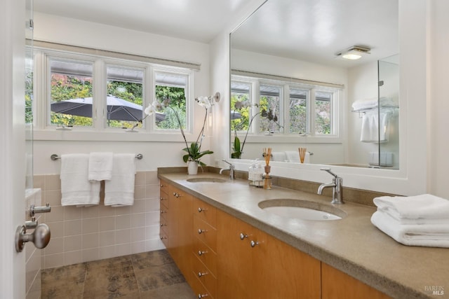 full bathroom featuring a sink, tile walls, and a healthy amount of sunlight