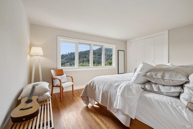 bedroom with a closet, baseboards, and wood finished floors