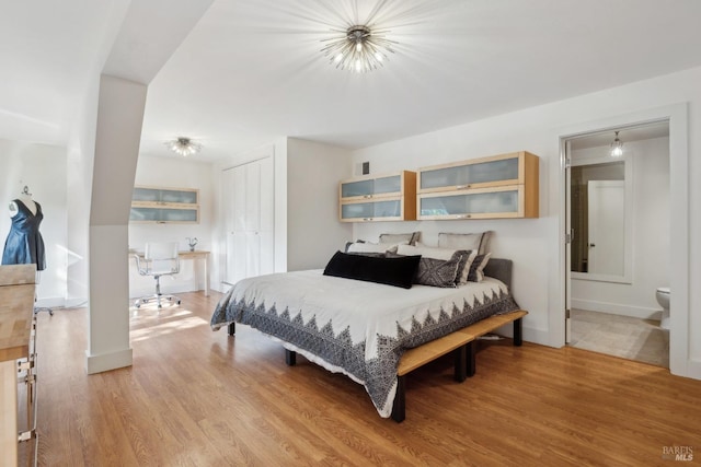 bedroom with a closet, baseboards, visible vents, and light wood finished floors