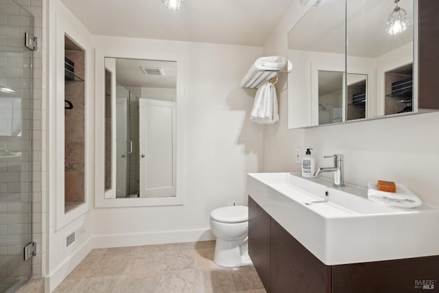 bathroom with visible vents, baseboards, toilet, vanity, and a shower stall