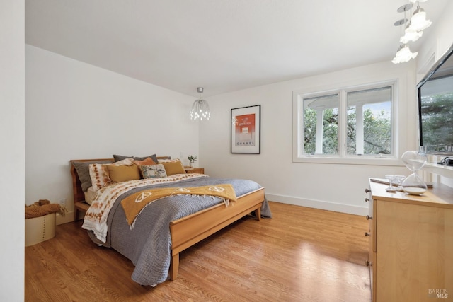 bedroom featuring light wood finished floors and baseboards