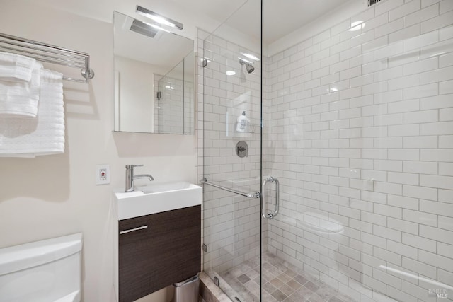 full bath featuring a stall shower, vanity, and toilet