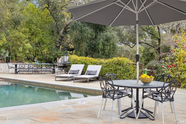 pool with a patio area and outdoor dining area